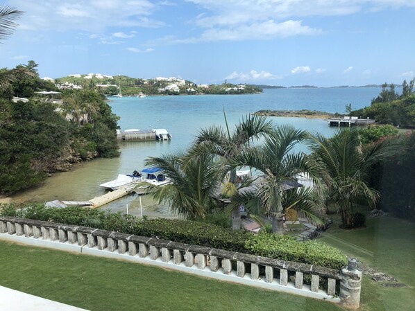 A marina with boats docked, surrounded by lush greenery and a clear view of the coastline.