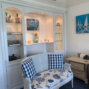Relax in the stylish living area with a classic sofa, console table, and shelving unit.