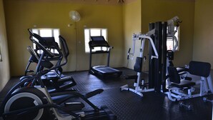 A gym with treadmills, elliptical machines, and weight equipment. - The Monet Place (Ocho Rios)