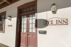 A building with a sign reading "ITZ INN" and a door labeled "Fret Porch Suite".
