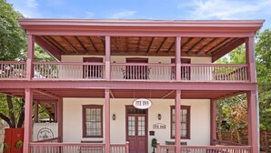 Un bâtiment à deux étages doté d’un balcon, d’une enseigne indiquant « ITZ INN » et d’une porte d’entrée.