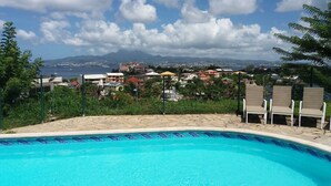 A swimming pool with a view of a coastal town and mountains in the background. - sea view apartment on the Caribbean (Les Trois-Îlets)