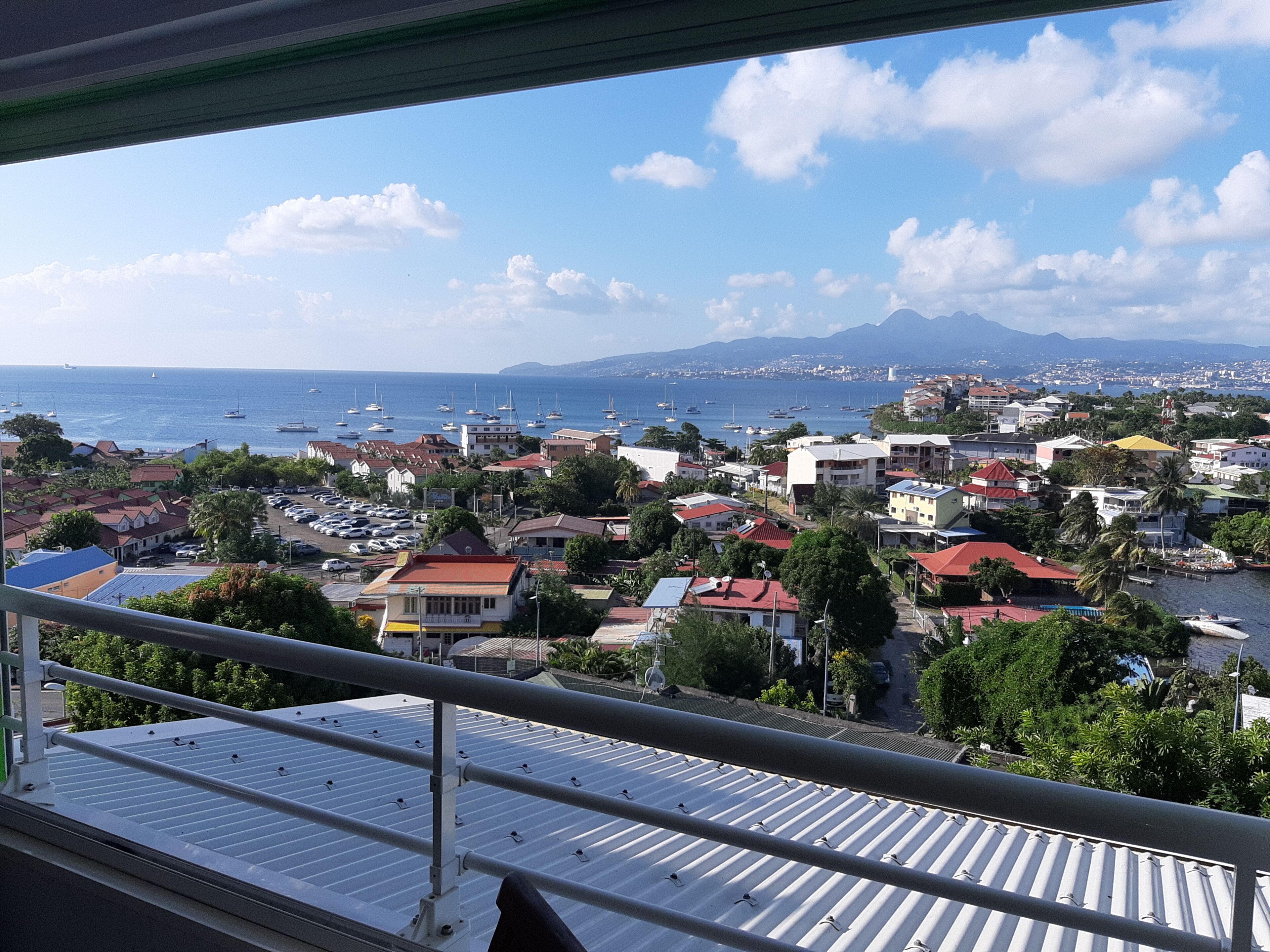 A coastal town with a view of the sea and mountains.