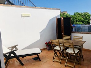 Enjoy a peaceful outdoor space with a patio featuring a table, chairs, and bench, offering a serene view of the surrounding landscape.