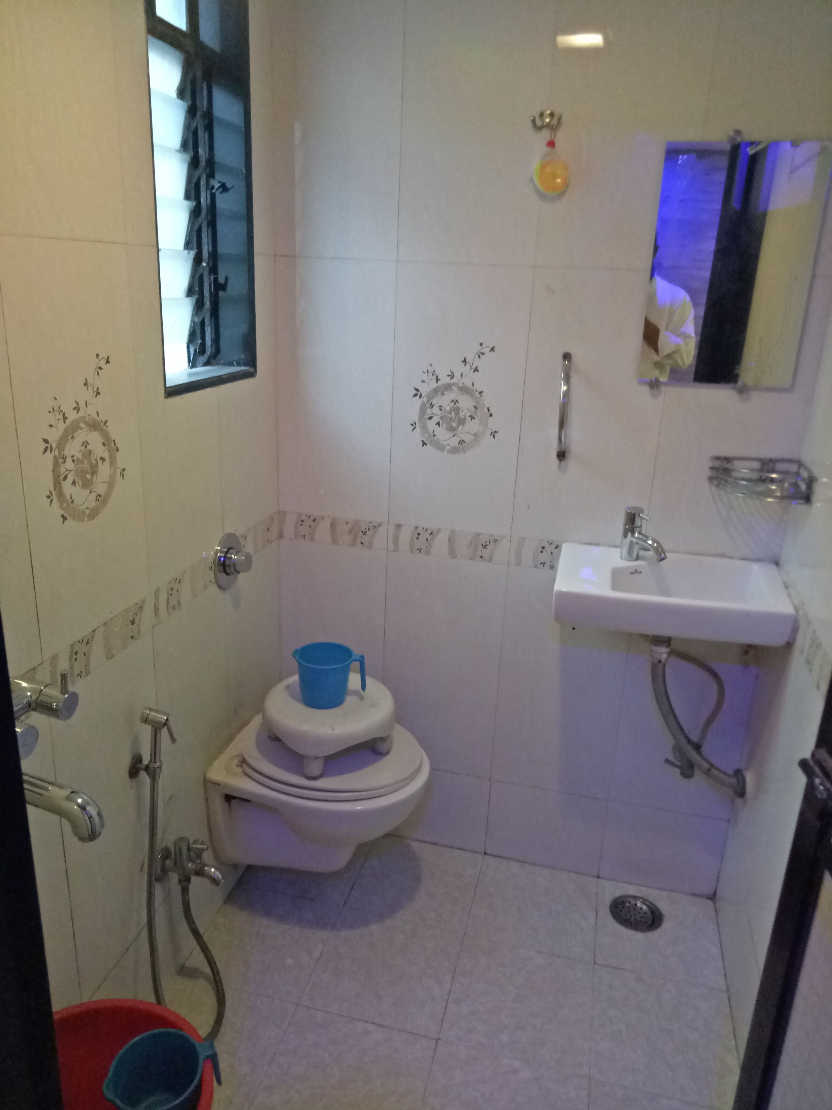 A small bathroom with a toilet, sink, and shower.