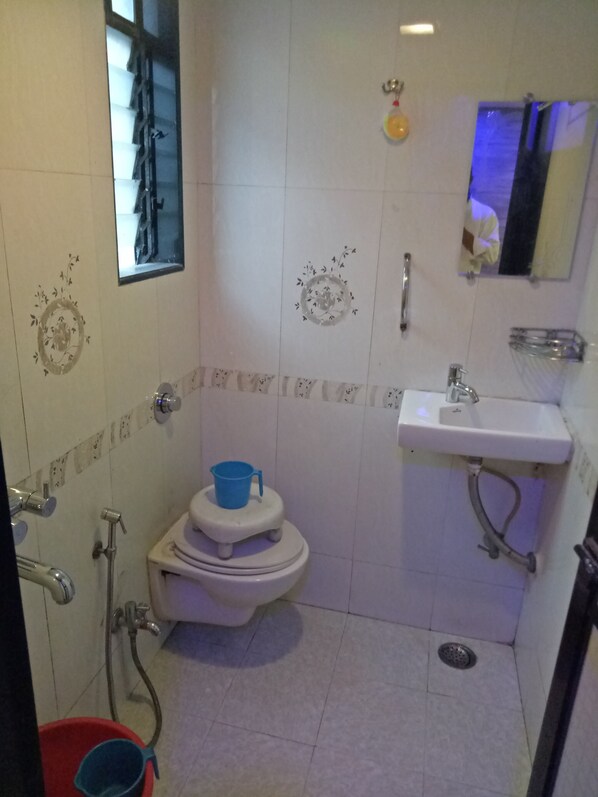 Une petite salle de bain avec des toilettes, un lavabo et une douche.