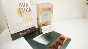 A calendar with the text "Bianchi Caffe" and a box of "Roasted Coffee" with a label that reads "Per te un assaggio de Napoli". - Mediterranean Rooms (Castellammare di Stabia)
