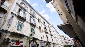A multi-story building with balconies, a sign for 'ANATOLI Viaggi', and a 'TABACCH' sign. - Mediterranean Rooms (Castellammare di Stabia)