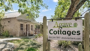 Señal de Agave Cottages con un número de contacto y sitio web.