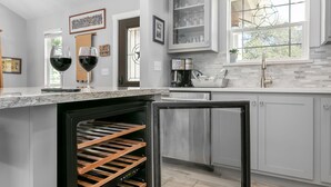Una cocina moderna con enfriador de vino integrado, electrodomésticos de acero inoxidable y ventana con vistas.