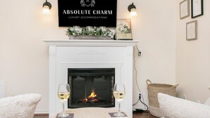 A fireplace with a sign above it reading "ABSOLUTE CHARM LUXURY ACCOMMODATIONS".