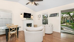 A modern living room with a fireplace, comfortable seating, and a view of the outdoors.