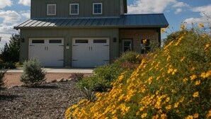 A two-story building with a garage and a small attached structure. - Distant Views | Incredible Views | Gas Fireplace | Queen Bed (Fredericksburg)