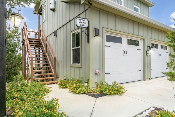 En toetagers bygning med garage, trappe og et skilt der viser 'DISTANT VIEWS B&B'.