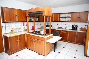A kitchen with wooden cabinets, a stove, and a microwave.