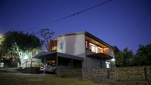 A two-story house with a covered garage and a brick wall. - Oudtshoorn Homestay Accommodation (Oudtshoorn)