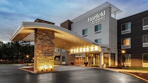 Un hôtel Fairfield Inn & Suites doté d’une façade moderne, d’un pilier en pierre et d’une entrée bien éclairée.
