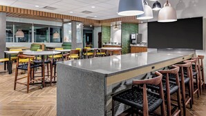 Un espace bar moderne doté d’un îlot central, de tabourets de bar et de sièges.