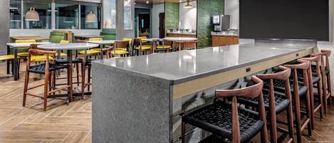 A modern bar area with a central island, bar stools, and seating.