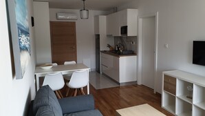 Une cuisine moderne avec des armoires blanches, une porte en bois et un four à micro-ondes encastré.