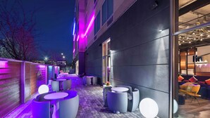 An outdoor seating area with modern furniture and ambient lighting. - Aloft by Marriott Cincinnati West Chester (West Chester)