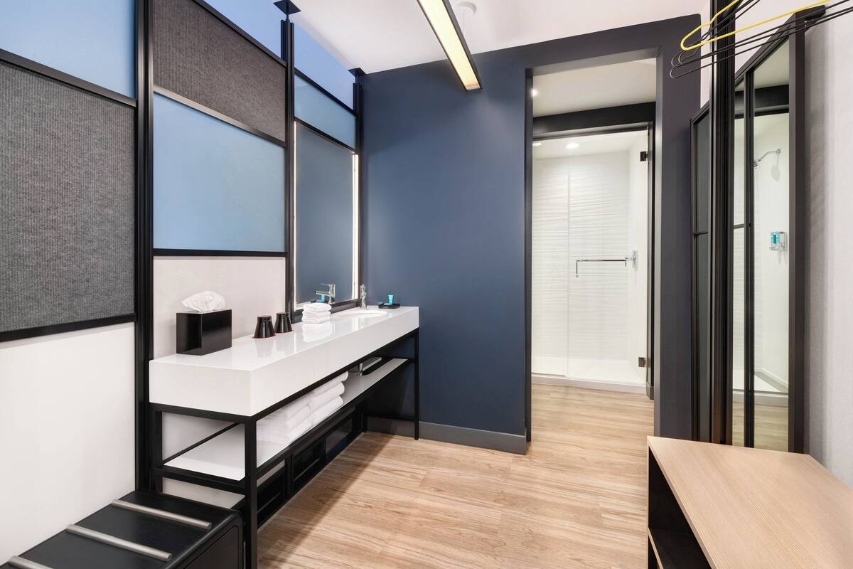 A modern bathroom with a white vanity, a mirror, and a shower area visible through a glass door.