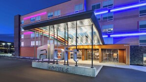 A modern hotel with a glass facade, a prominent 'a laft' sign, and a brick exterior. - Aloft by Marriott Cincinnati West Chester (West Chester)