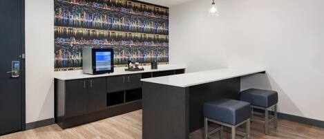 A modern kitchen with a large island, bar stools, and a cityscape mural on the wall.