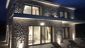 Un edificio a due piani con facciata in pietra e ampie finestre.