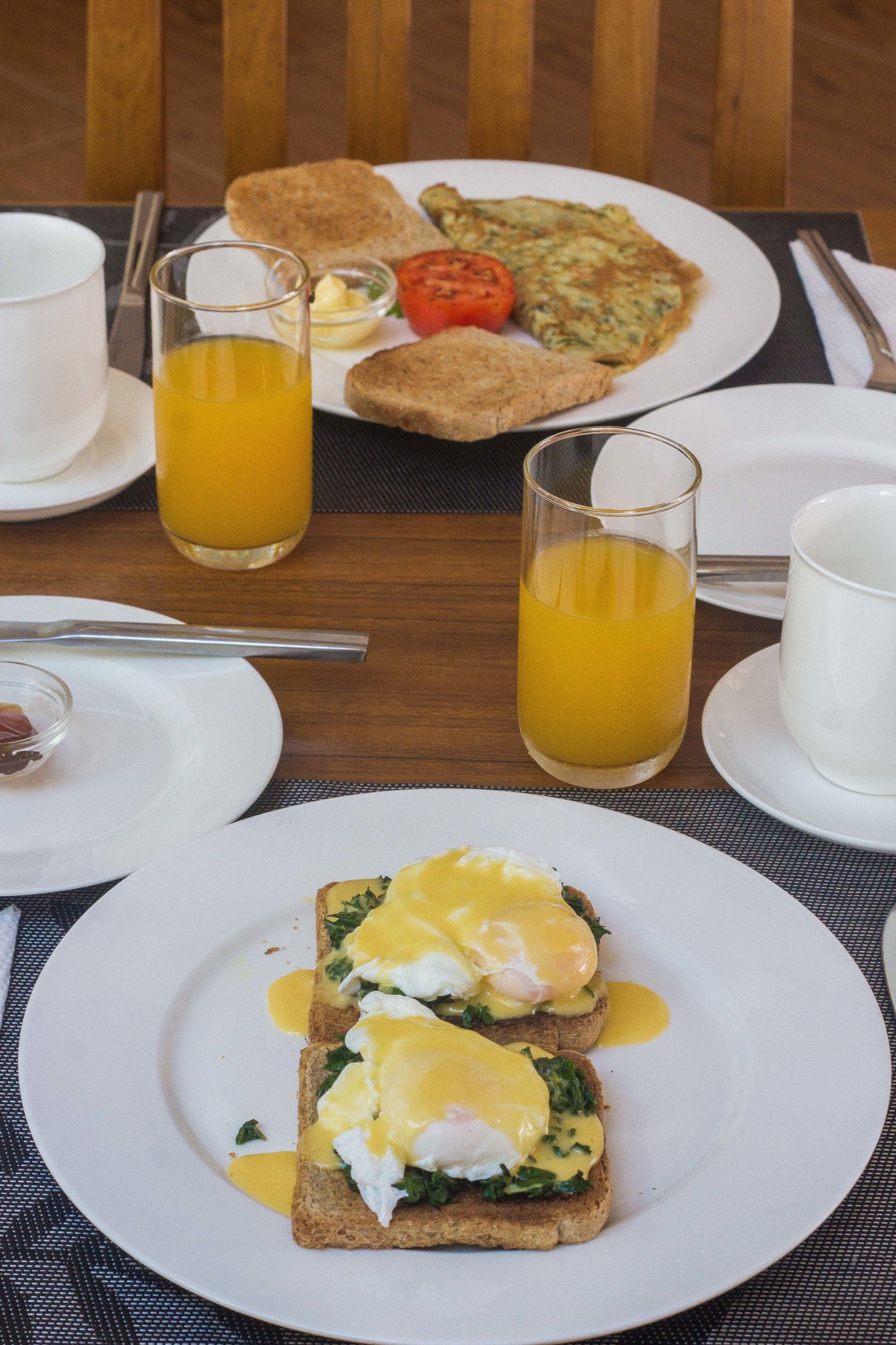 Un desayuno con tostadas, huevos y jugo.