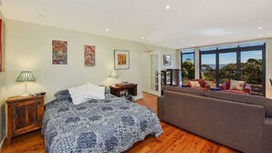 A bedroom with a large bed, a sofa, and a view of the outdoors. - Narrow Neck Views - Spacious Mountains Home with Stunning Views! (Katoomba)
