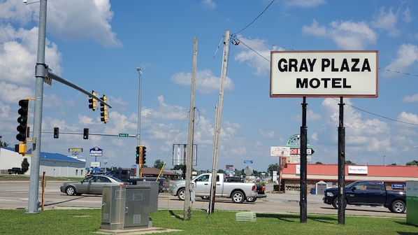 Un letrero de motel con el nombre "GRAY PLAZA MOTEL" y una señal de calle que indica "Russell St."