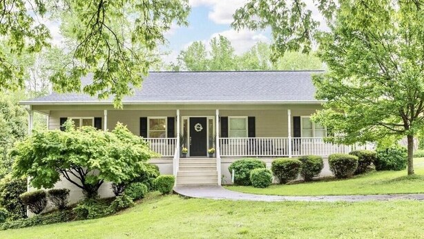 A single-story house with a front porch, a door with a wreath, and a small front yard with bushes and a tree. - Walk to Carrollton Square!  Entire Home Upstairs For Rent.  (Carrollton)