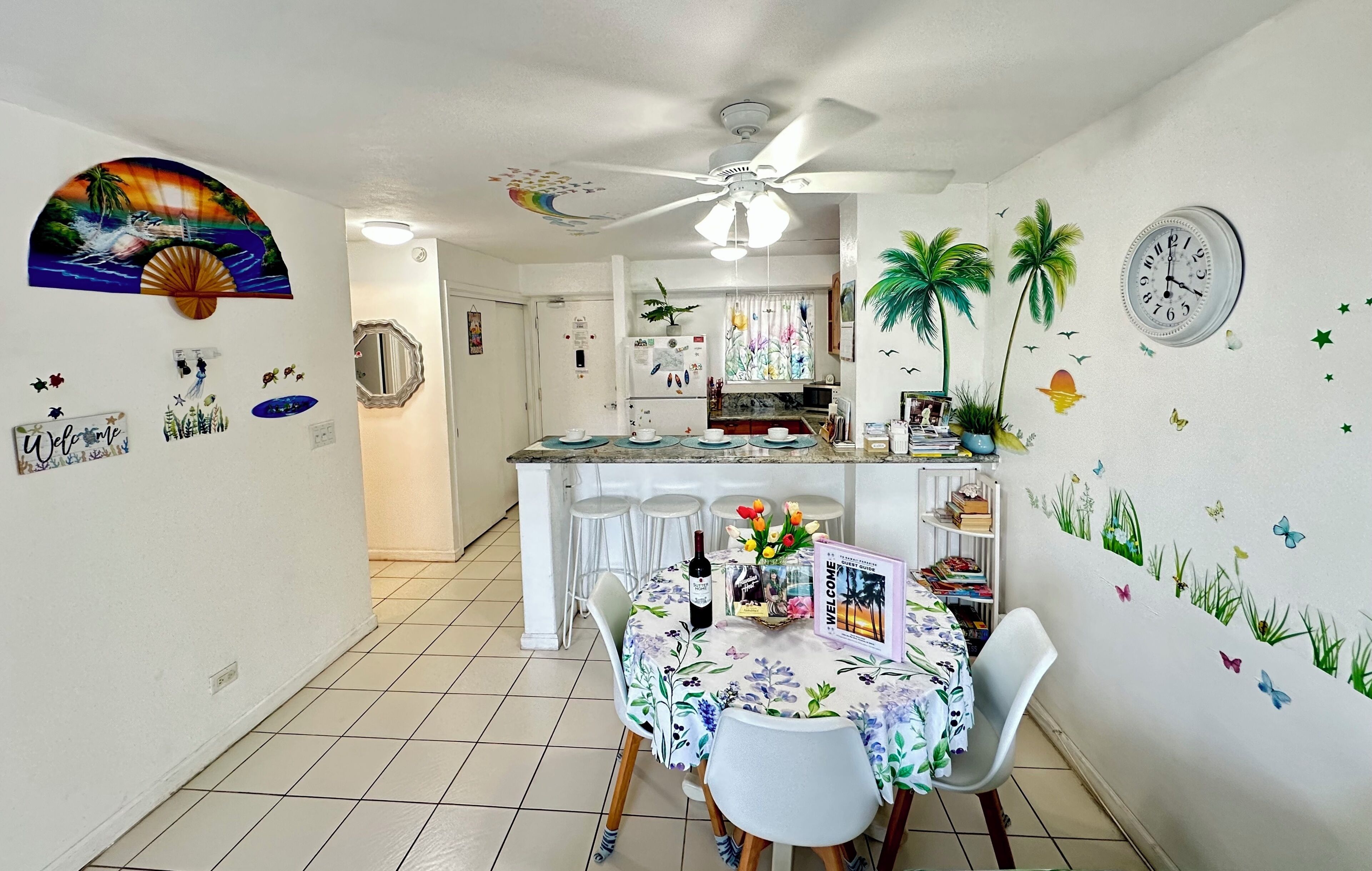 Una cocina con comedor, paredes blancas y un ventilador de techo.