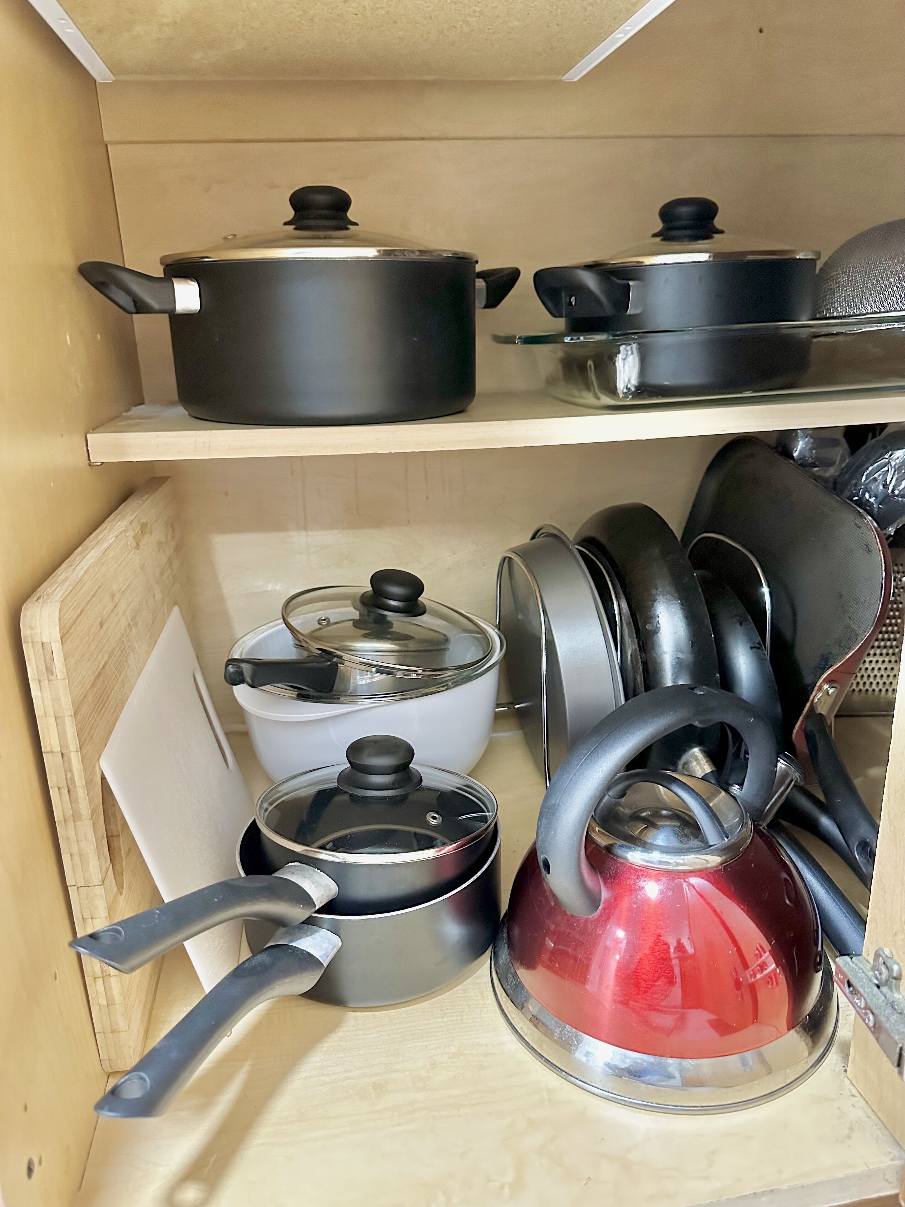 A kitchen with wooden shelves holding various pots and pans.
