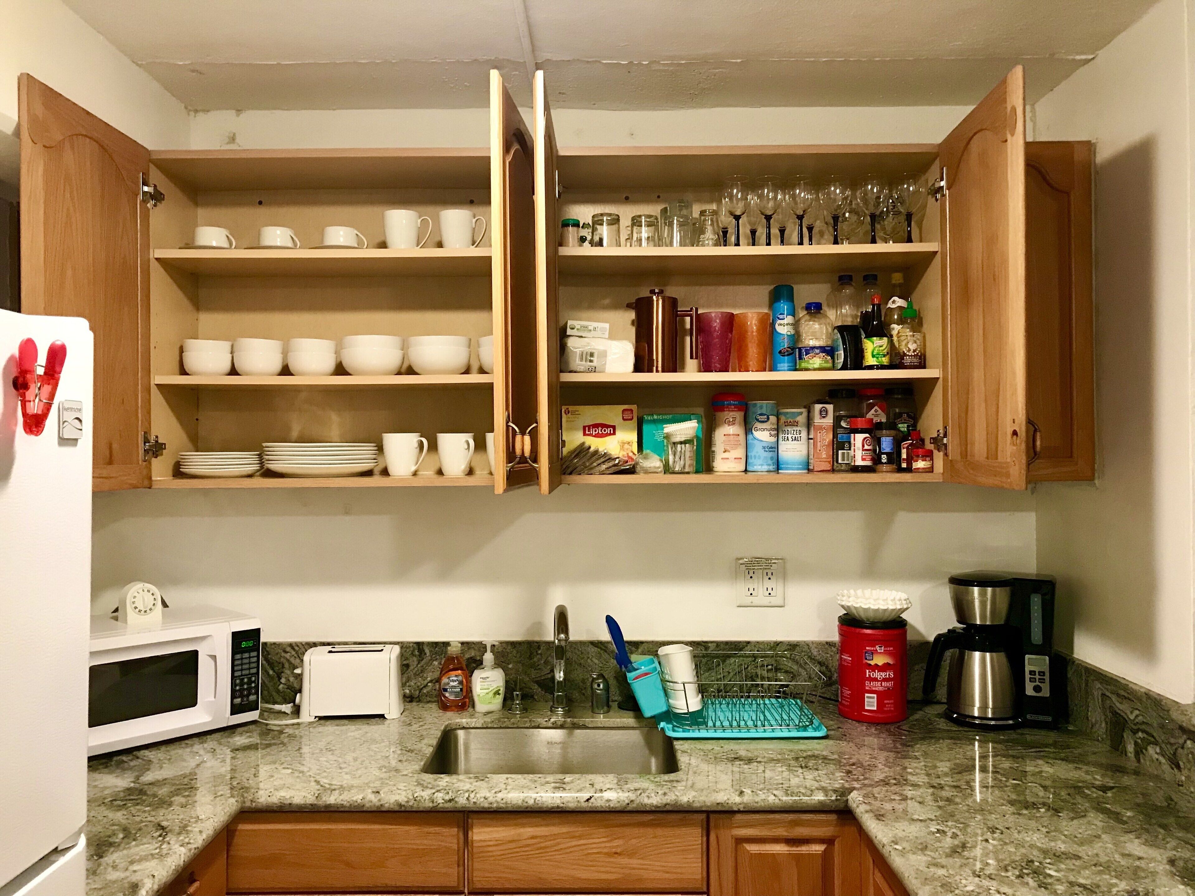 A kitchen with wooden cabinets, a microwave, a toaster, and a coffee maker.