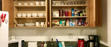A kitchen with wooden cabinets, a microwave, a toaster, and a coffee maker.