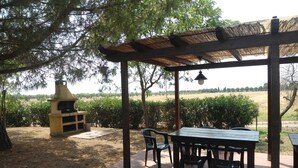 An outdoor patio area with a grill, seating, and a view of the countryside. - LE PESCINE - Casa Oliveta: Spighe [OP] (Vada)
