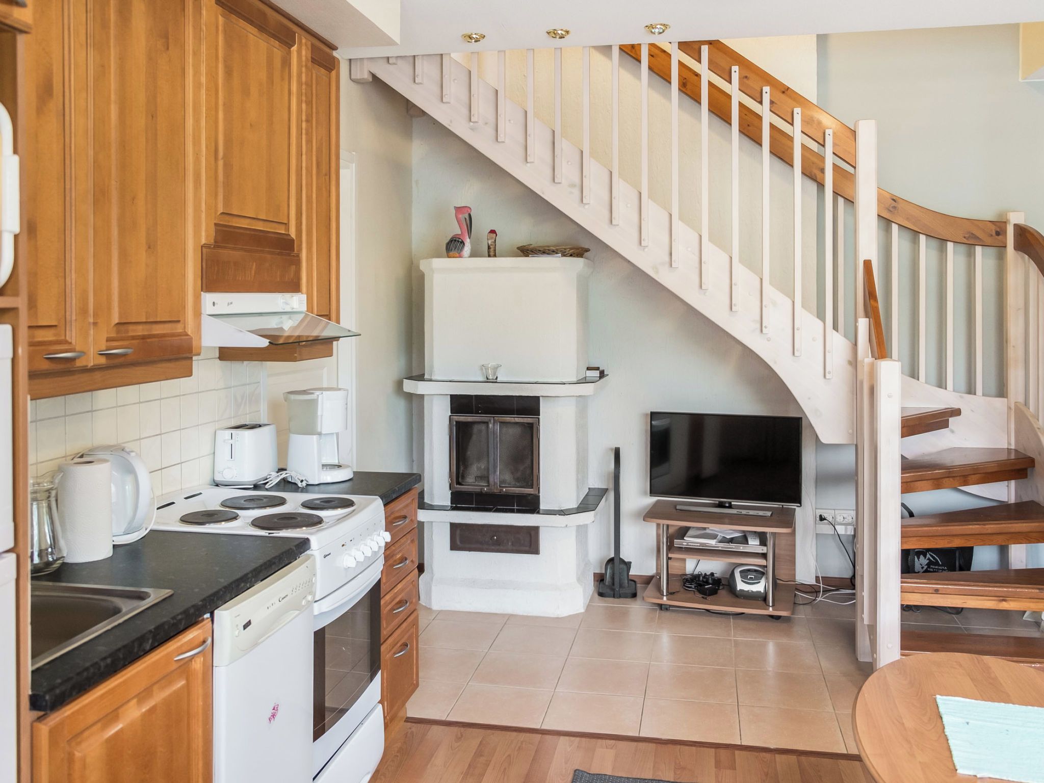 A kitchen with wooden cabinets, a stove, a sink, and a built-in oven.