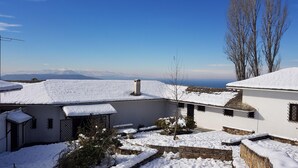 Een sneeuwbedekte binnenplaats met uitzicht op verre bergen.