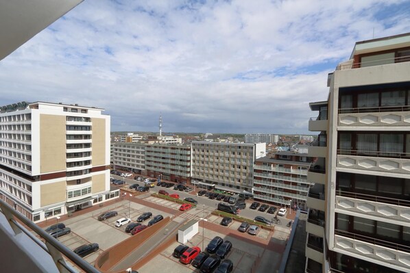 A multi-story parking lot with several cars, surrounded by modern buildings with balconies. - House Metropol, App. 109 (Westerland)