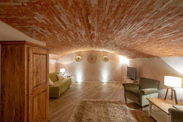 Relax in this charming attic room with a vaulted ceiling, comfortable seating area, and flat-screen TV.