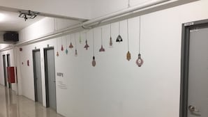 Un couloir avec des portes, une enseigne sur laquelle on peut lire « ESPOIR », et des luminaires suspendus.