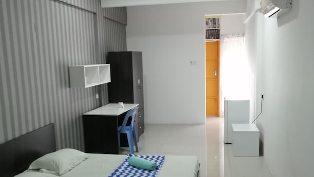Une chambre d’hôtel moderne équipée d’un lit, d’un bureau, d’une armoire et d’une salle de bain.