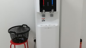Un distributeur d’eau doté d’un écran numérique, d’un panier et d’une petite plante fixée au mur.