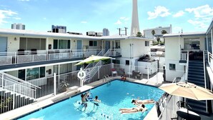 A hotel pool area with a view of a tall tower in the background. - 3BR Condo SALE nexttoSTRIP nearLVCC sale modern stylish WiFi pool Labor Day Sema (Las Vegas)