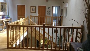 A spacious loft with wooden beams, a staircase, and a view of the outside. - A spacious vacation rental perfect for family getaways: games, nature, and tranquility (Villotte-sur-Aire)