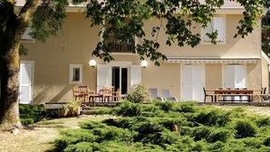 A two-story building with a garden in front. - A spacious vacation rental perfect for family getaways: games, nature, and tranquility (Villotte-sur-Aire)
