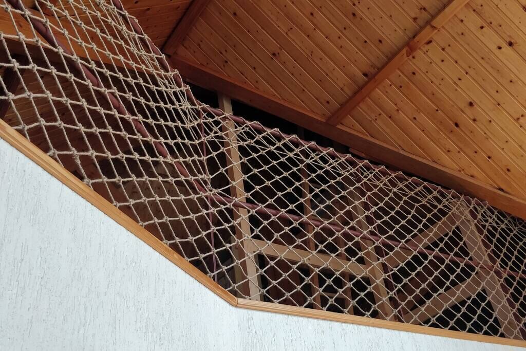Una escalera de madera con una barrera de red.