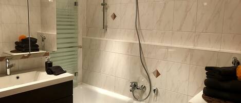 Bathtub, hair dryer, slippers, towels